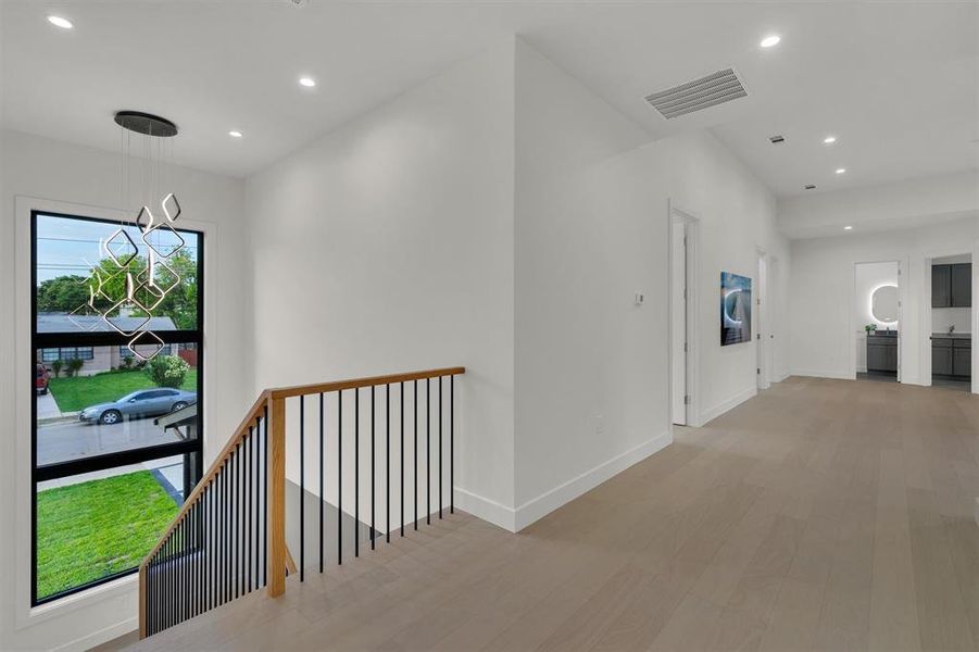 Hall with a notable chandelier and light hardwood / wood-style flooring