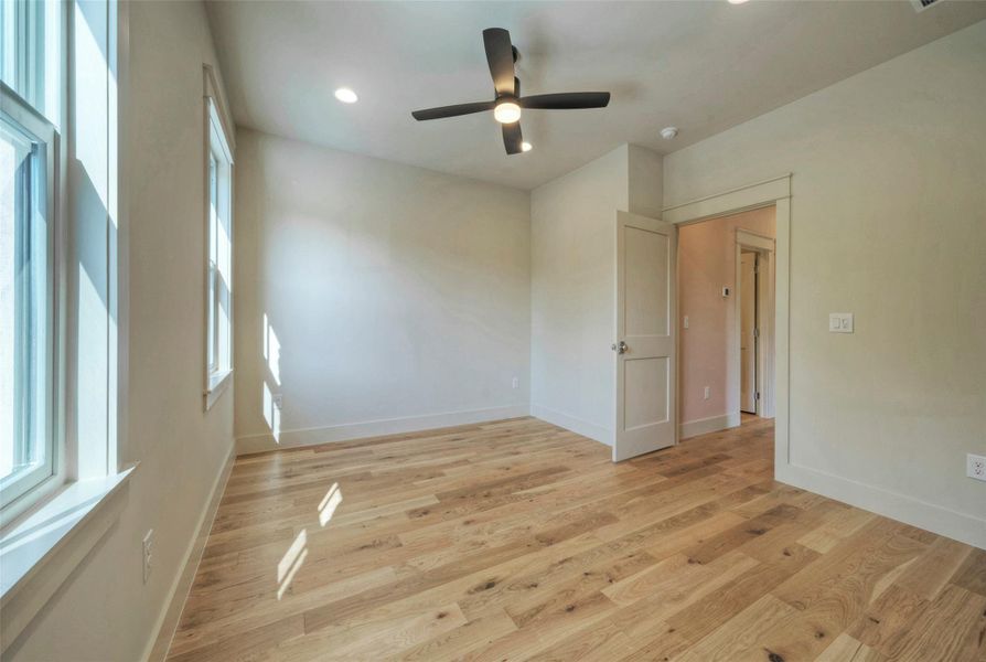 Primary Bedroom with warm hardwood floors and ample natural light.