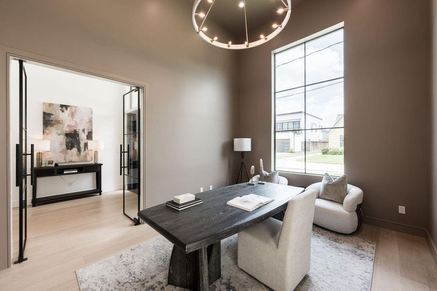 Tailored and tranquil, this dedicated home office pairs warm wood tones with abundant natural light. A clean-lined desk anchors the room, while full-height windows frame leafy views—offering a refined environment for productivity without sacrificing comfort.