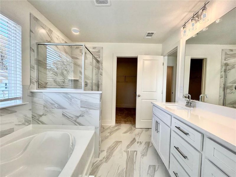 Bathroom featuring independent shower and bath, tile floors, and oversized vanity