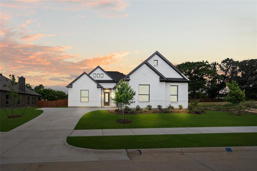 Modern farmhouse featuring concrete driveway and landscaped curb appeal