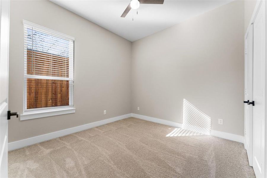 Spare room featuring ceiling fan and light colored carpet