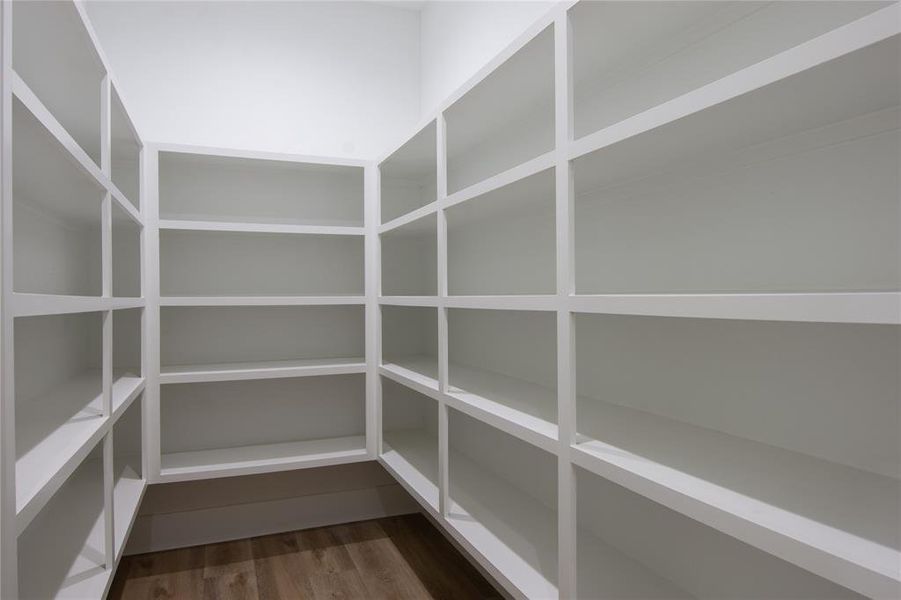 Walk-in pantry with many shelves offering ample storage for kitchen essentials. Walk-in pantry with many shelves offering ample storage for kitchen essentials.