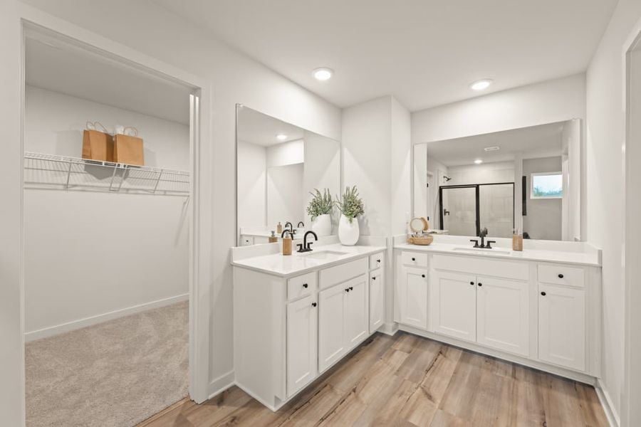 A bathroom with white cabinets.