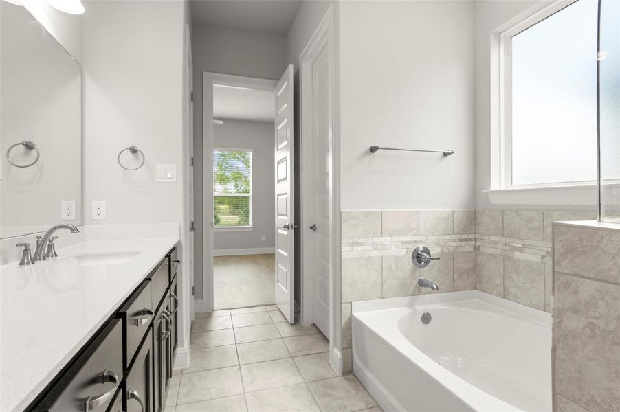 Bathroom featuring vanity, a bath, and tile patterned floors Bathroom featuring vanity, a bath, and tile patterned floors