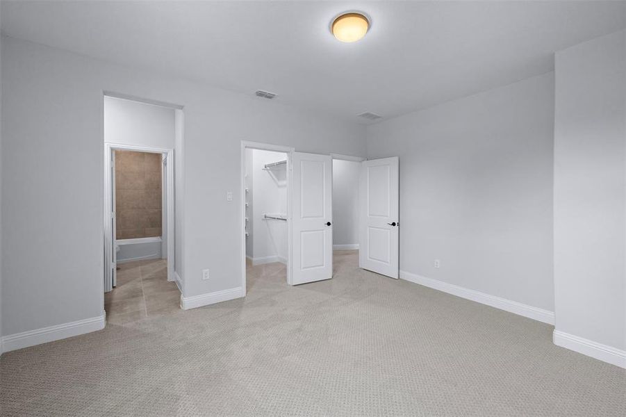Unfurnished bedroom with carpet and a walk in closet