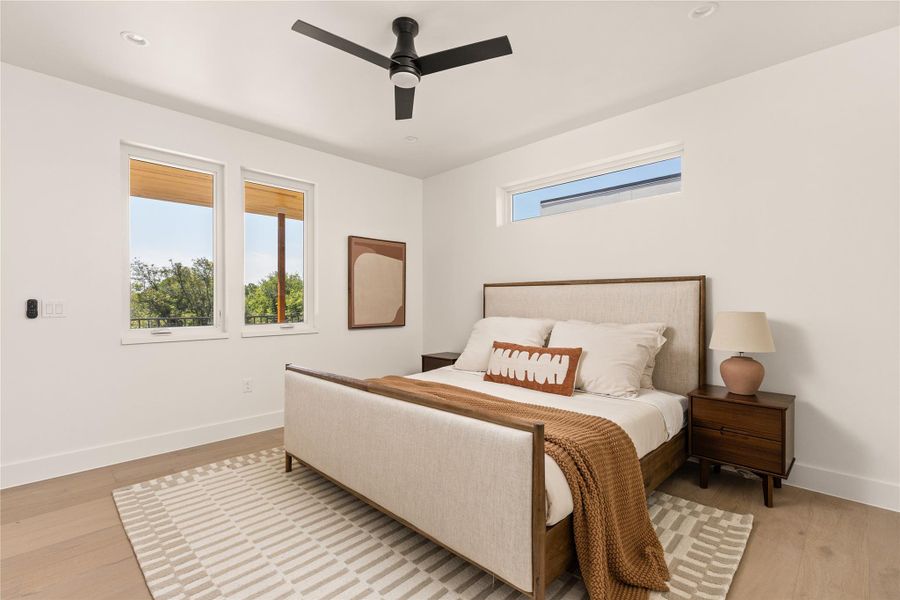 Bedroom featuring multiple windows, a ceiling fan, and light wood finished floors