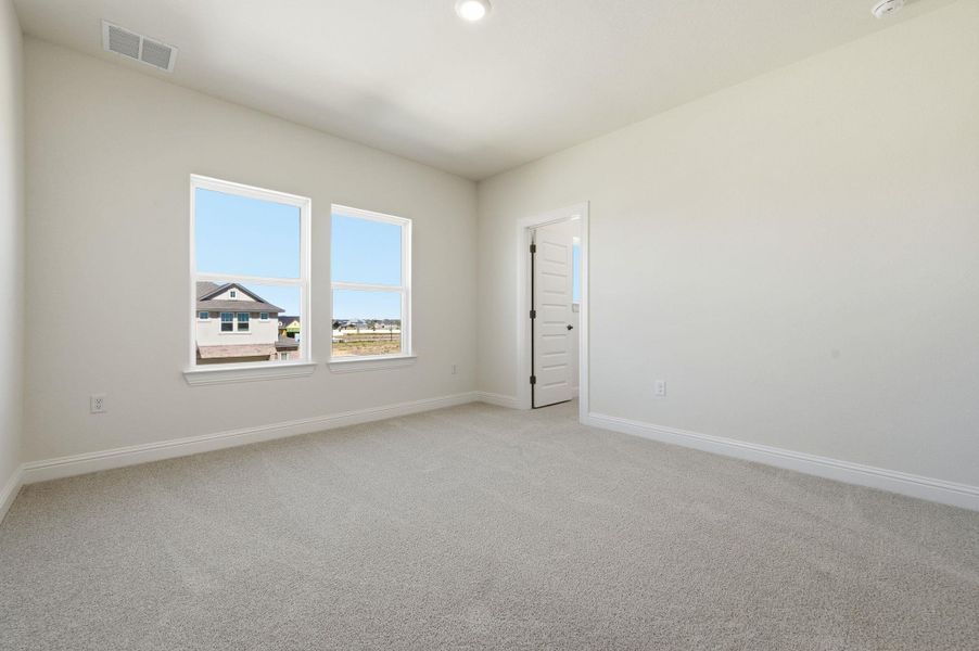 Spare room with light carpet and baseboards