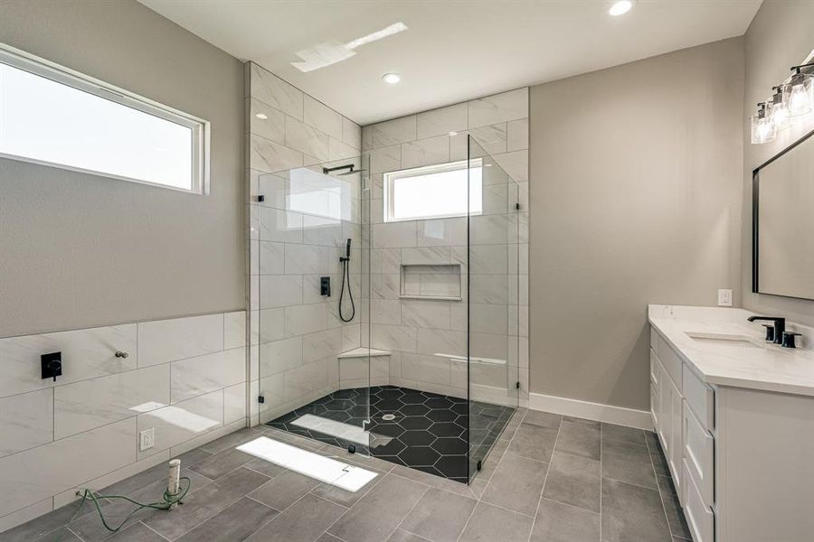 Bathroom featuring vanity and a tile shower