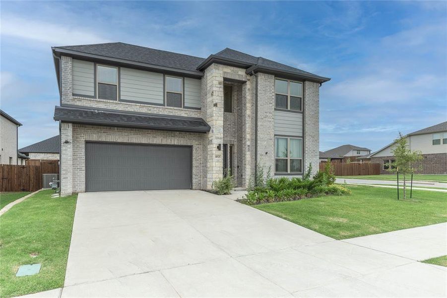View of front of house featuring brick siding, an attached garage, concrete driveway, and roof with shingles