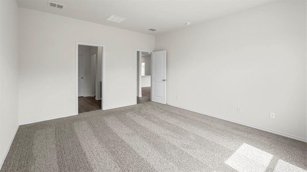 Spacious room featuring light gray carpeting, neutral wall finishes, and recessed lighting