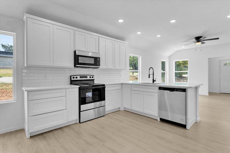 Kitchen featuring appliances with stainless steel finishes, light wood-type flooring, and sink