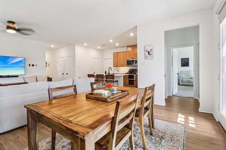 Dining room featuring light wood-style floors, recessed lighting, and a ceiling fan Dining room featuring light wood-style floors, recessed lighting, and a ceiling fan