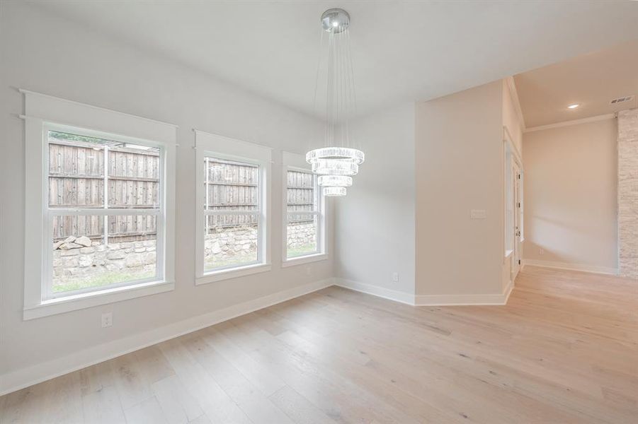 Unfurnished dining area with light wood finished floors, recessed lighting, and a chandelier