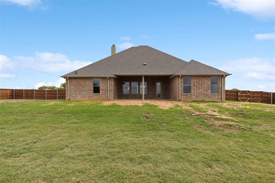 Rear view of property with a lawn