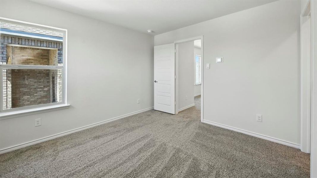 Carpeted empty room with baseboards