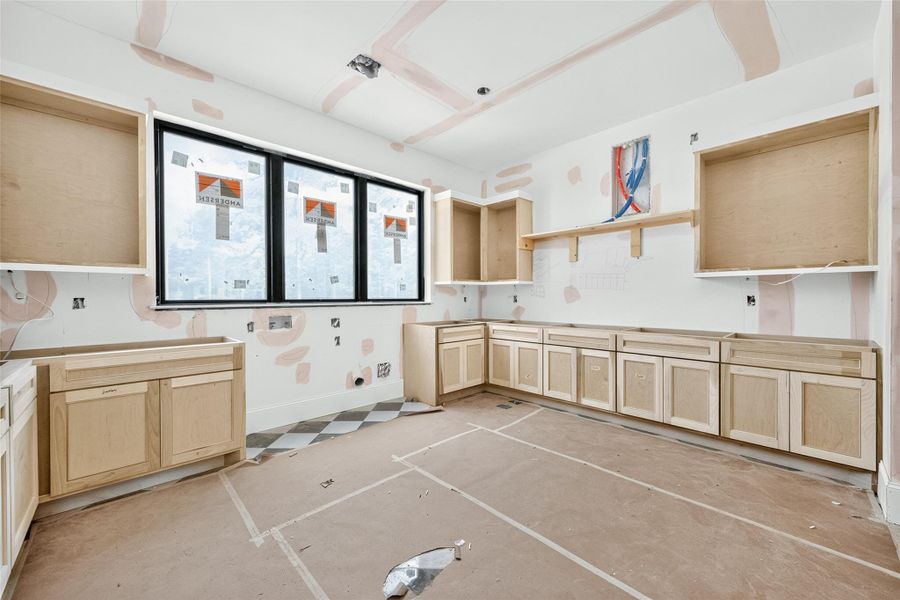 Spacious laundry room across from the primary closet for convenience with windows overlooking the front yard