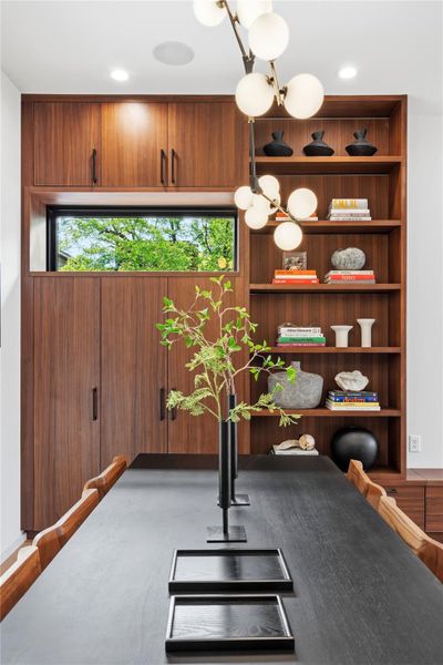 Elegant built-in shelving complements the sleek dining table, perfect for gatherings.