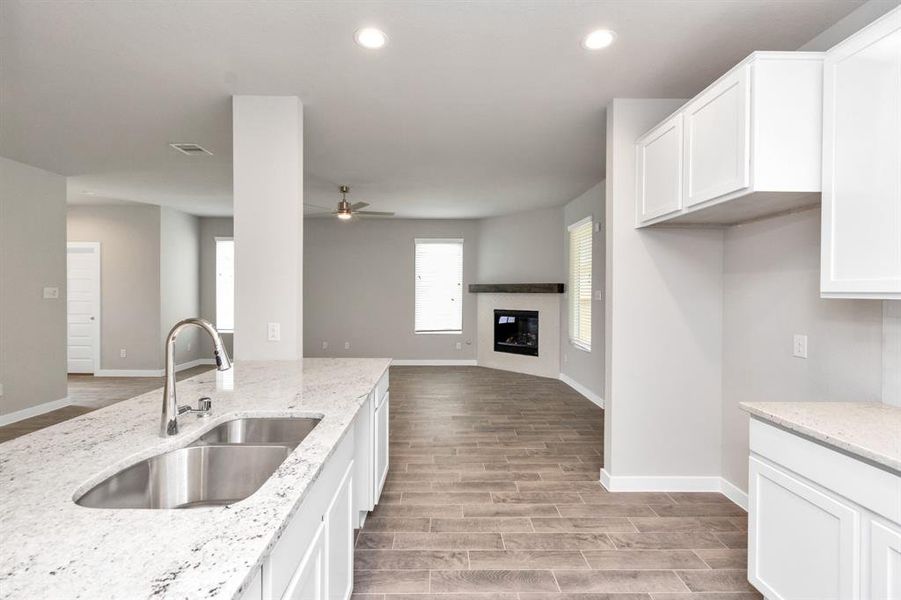 Discover another perspective of this stunning kitchen, generously appointed with an abundance of counter space. Sample photo of completed home with similar floor plan. As-built interior colors and selections may vary.