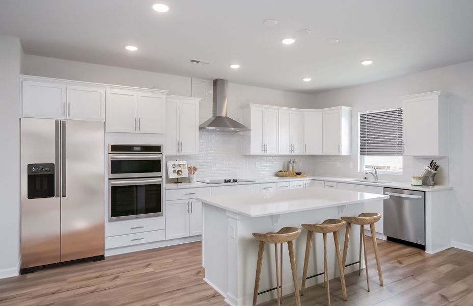 Bright white Kitchen with an island.