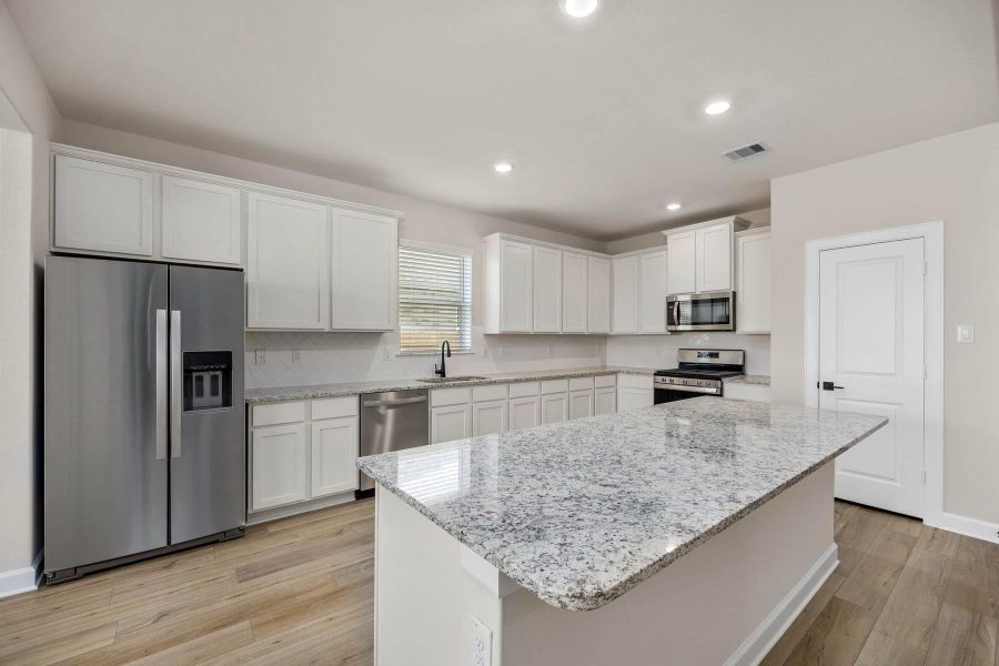 Step into this beautifully designed kitchen boasting a spacious island with a large breakfast bar overlooking the living room, a chic herringbone pattern backsplash, and modern stainless steel appliances. Perfect for entertaining and everyday living! Step into this beautifully designed kitchen boasting a spacious island with a large breakfast bar overlooking the living room, a chic herringbone pattern backsplash, and modern stainless steel appliances. Perfect for entertaining and everyday living!