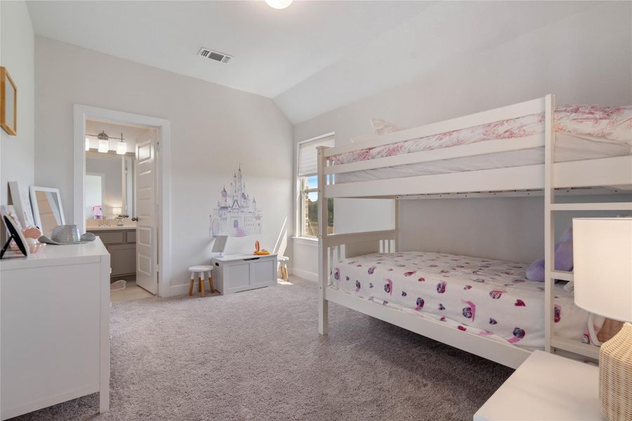 High ceilings and bathroom access in this bedroom.