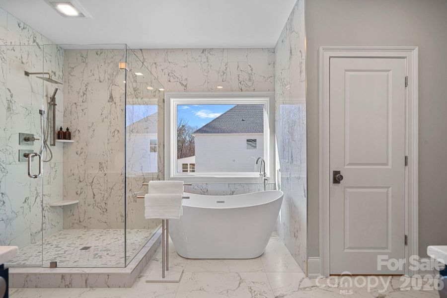 Primary Bathroom is luxuriously complete with multi-zone spray head shower, gorgeous soaking tub, custom double vanities and huge walk in closet.