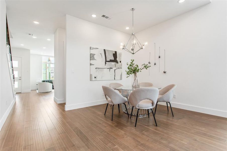 Dining room with wood-type flooring and a chandelier