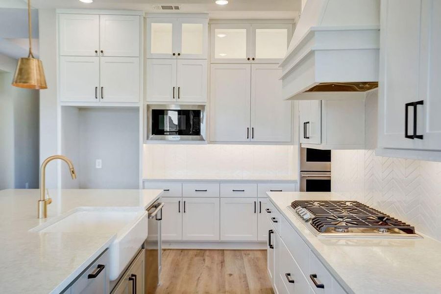 EXAMPLE PHOTO: Gas cooktop with stainless updraft vent hood. EXAMPLE PHOTO: Gas cooktop with stainless updraft vent hood.