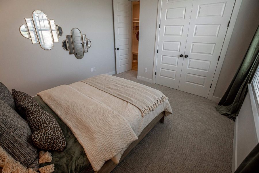 Plush carpeting extends throughout this room, featuring two sets of paneled double doors with black hardware