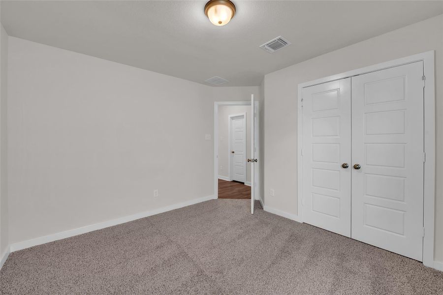 Unfurnished bedroom with carpet and a closet Unfurnished bedroom with carpet and a closet