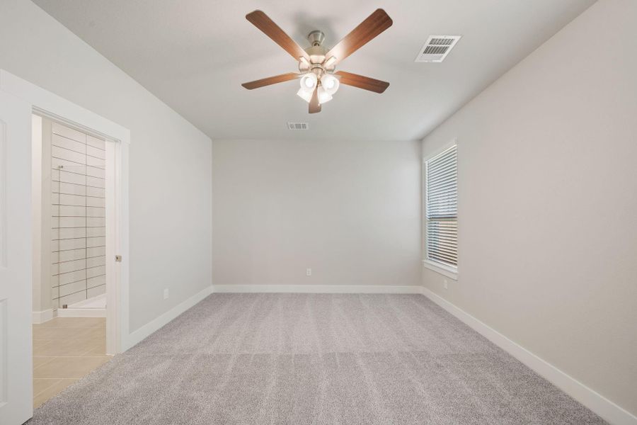 Natural sunshine spills through both of the windows of this generously-sized primary bedroom. Natural sunshine spills through both of the windows of this generously-sized primary bedroom.