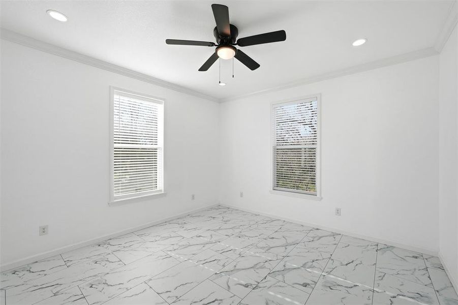 Unfurnished room featuring crown molding, light marble finish floors, and ceiling fan Unfurnished room featuring crown molding, light marble finish floors, and ceiling fan
