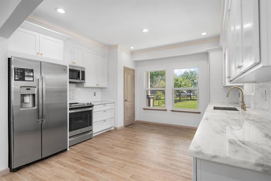 The kitchen has GORGEOUS quartz countertops, gold fixtures and 42 inch cabinets!