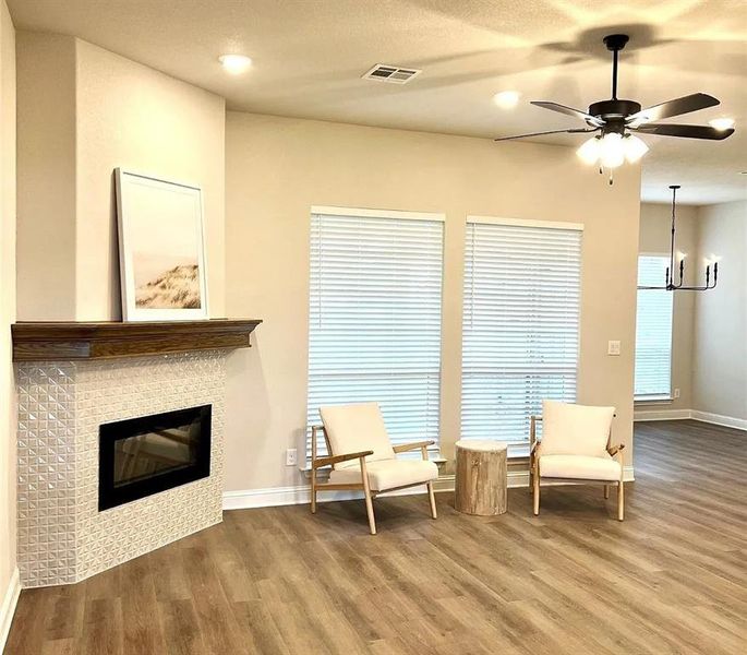 Living space with wood-finish flooring, recessed lighting, and a ceiling fan with light fixture Living space with wood-finish flooring, recessed lighting, and a ceiling fan with light fixture