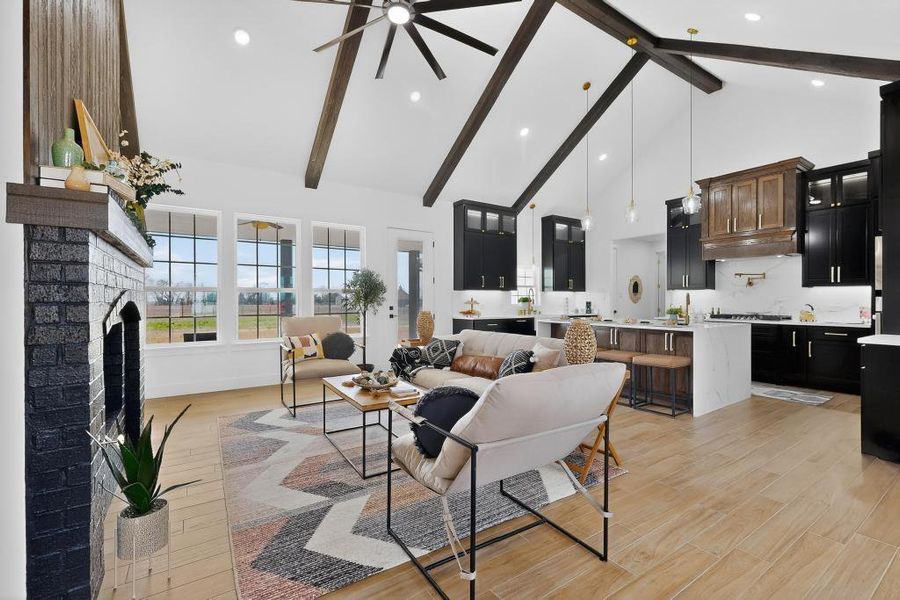 Living area featuring light wood-type flooring, a brick fireplace, ceiling fan, and recessed lighting