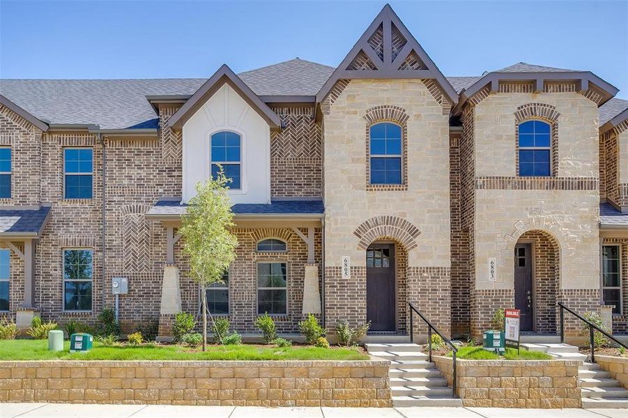 French provincial home with brick siding, a shingled roof, and stone siding French provincial home with brick siding, a shingled roof, and stone siding
