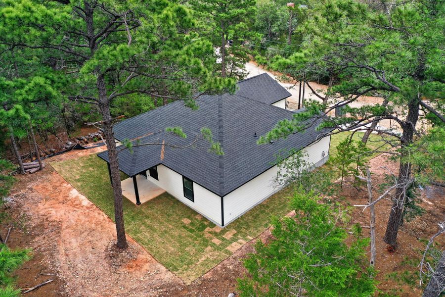 Modern residence featuring white siding and a dark shingle roof Modern residence featuring white siding and a dark shingle roof