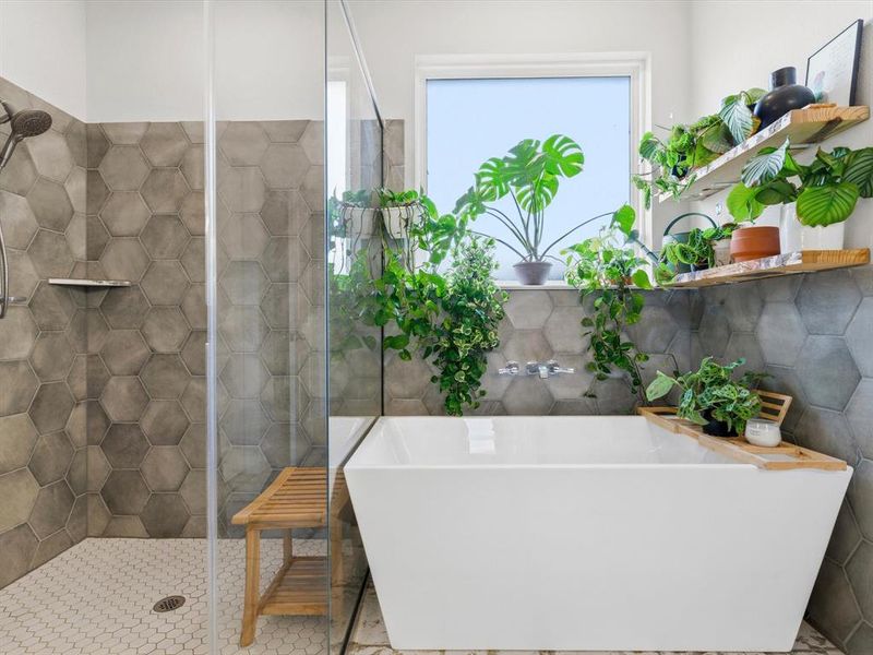 Primary bathroom featuring dual vanities, soaking tub, and separate shower.