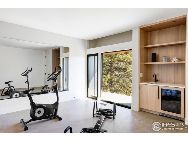 The home gym gets pulses racing with a built-in wet bar and attached patio with wide-open treetop views, while a secondary bedroom suite offering a walk-in closet, private bathroom and outdoor access is perfect for guests. The home gym gets pulses racing with a built-in wet bar and attached patio with wide-open treetop views, while a secondary bedroom suite offering a walk-in closet, private bathroom and outdoor access is perfect for guests.