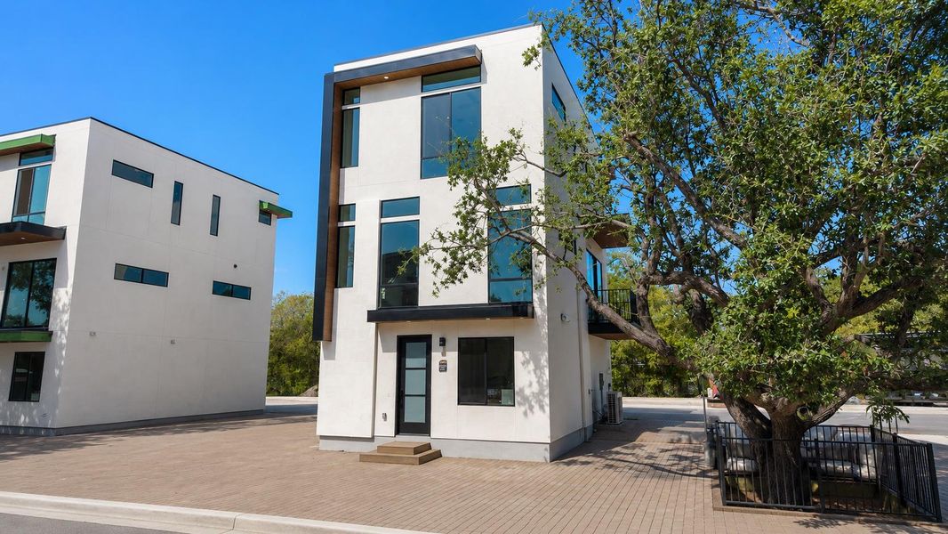 Modern architecture with a white stucco facade, large multi-pane windows, and a dark-framed entry door