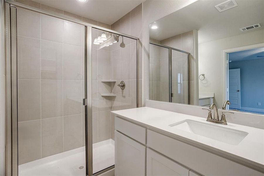 Bathroom with vanity and a shower with door