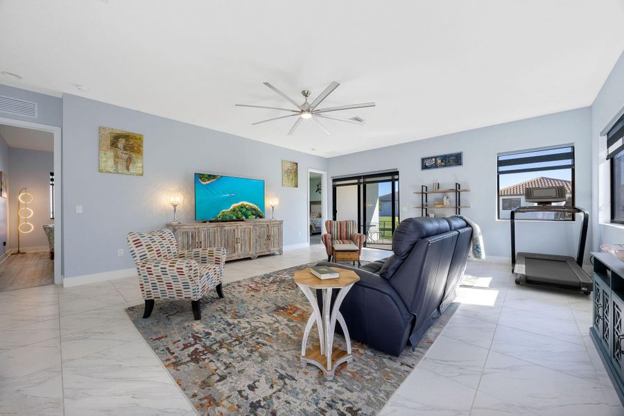 Living room with light marble finish flooring and a ceiling fan