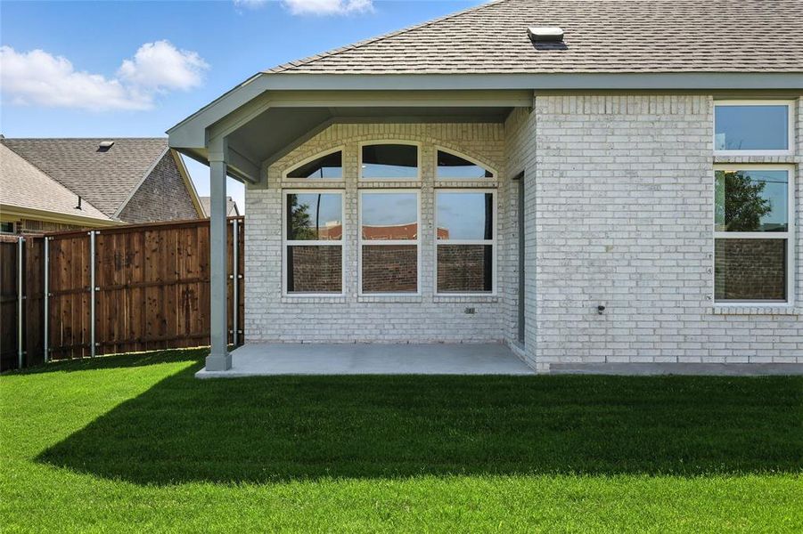 Rear view of property featuring brick siding, a patio area, and a shingled roof Rear view of property featuring brick siding, a patio area, and a shingled roof