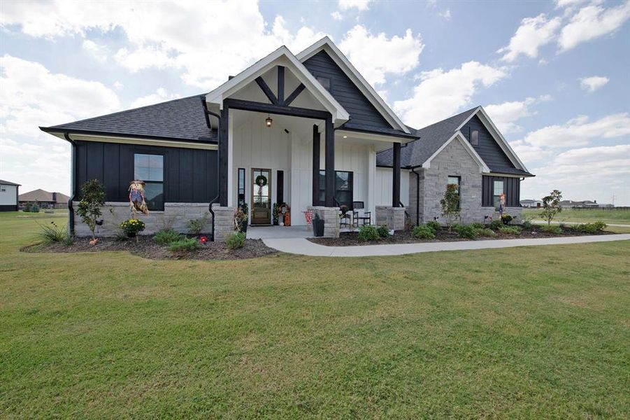 Modern farmhouse with covered porch, board and batten siding, and a front yard