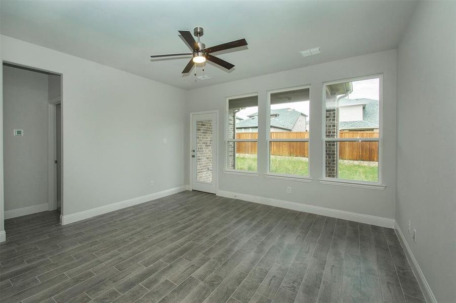 Spare room with baseboards, dark wood-style floors, and a ceiling fan Spare room with baseboards, dark wood-style floors, and a ceiling fan