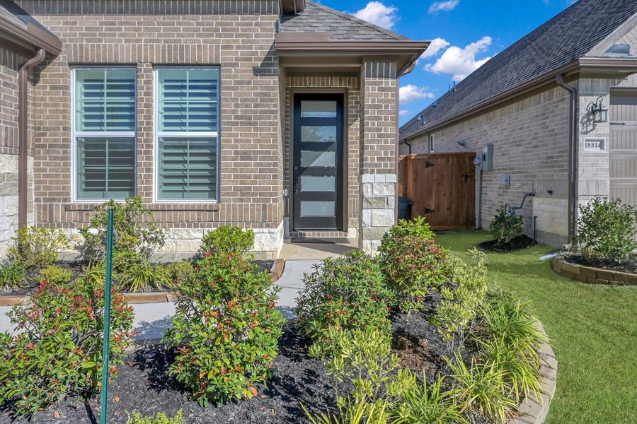 The driveway sidewalk leads to the covered front porch with a five panel front door including privacy glass. The garage floor has been coated with epoxy.