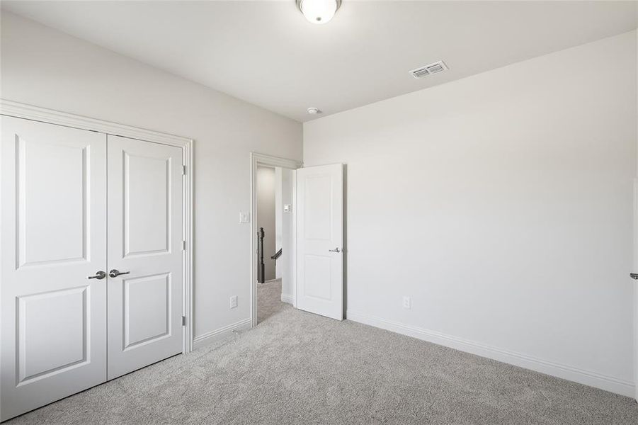 Unfurnished bedroom featuring carpet flooring and a closet Unfurnished bedroom featuring carpet flooring and a closet