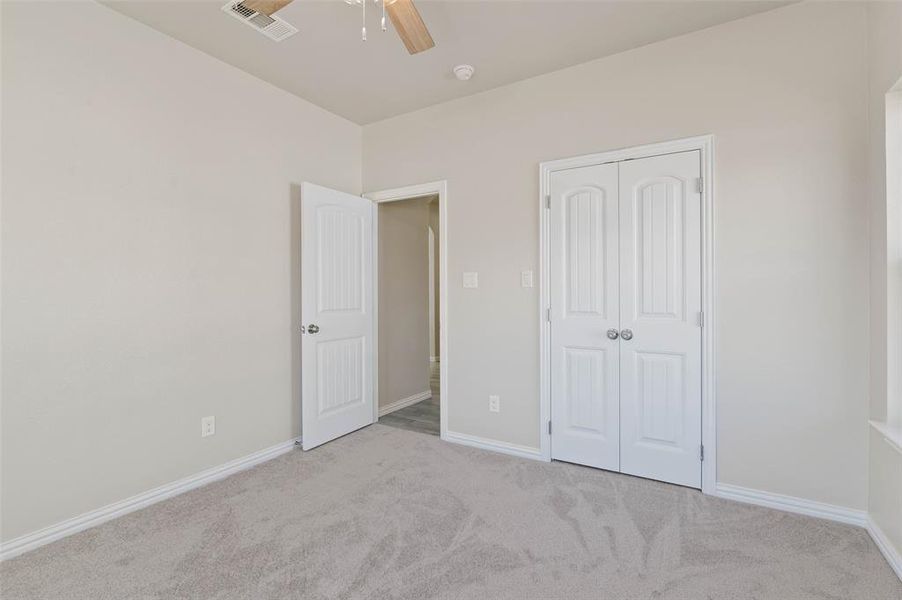 Unfurnished bedroom featuring a closet, light colored carpet, and ceiling fan Unfurnished bedroom featuring a closet, light colored carpet, and ceiling fan
