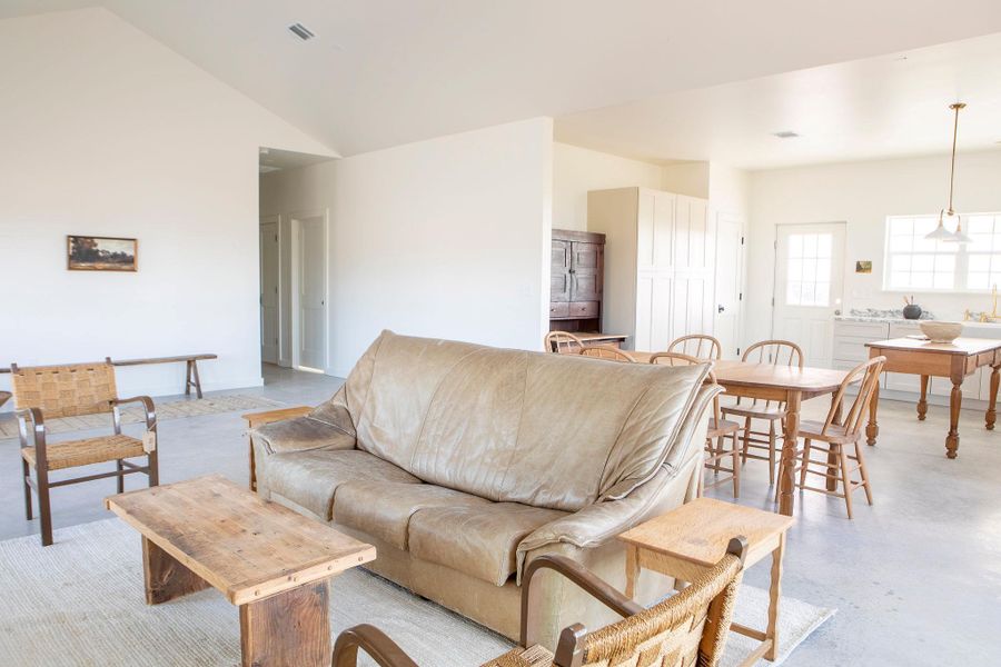 Living room featuring finished concrete floors and lofted ceiling Living room featuring finished concrete floors and lofted ceiling